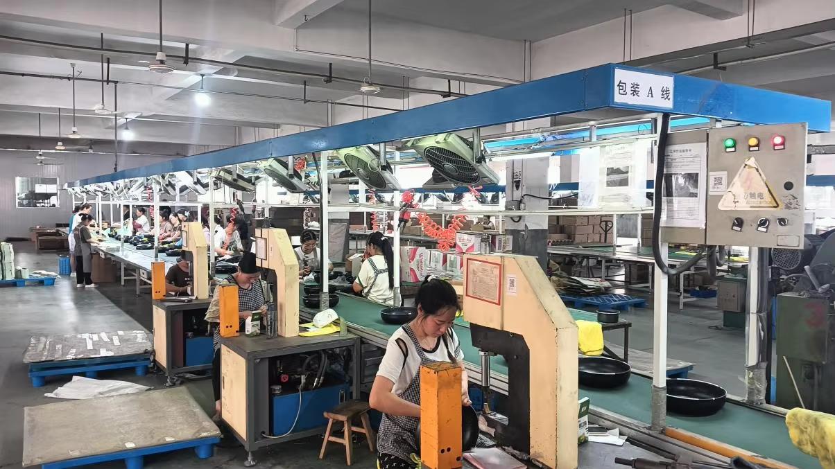 Workers assembling nonstick frying pans